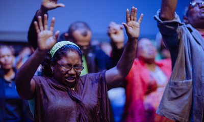 woman raising hands in prayer